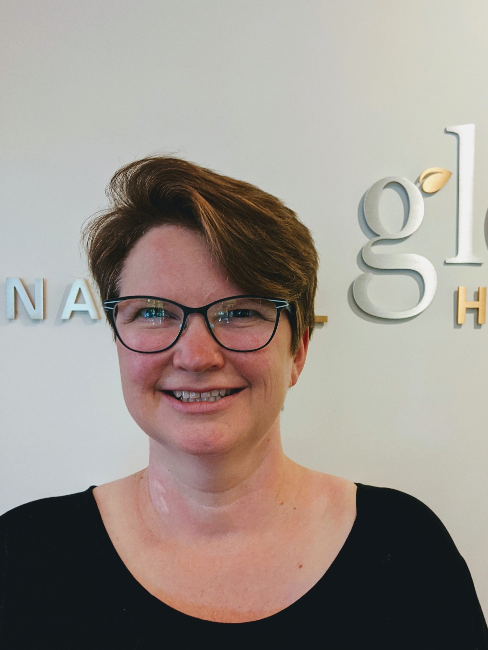 heather in front of Glow sign