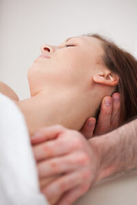 Close-up of neck of woman beig manipulating by a therapist